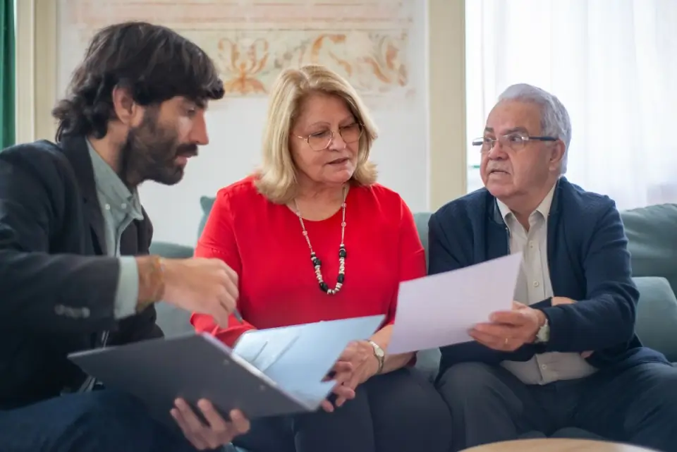 Consultor conversando com um casal de idosos sobre documentos